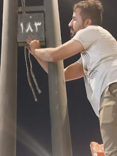 مواطن من ذي قار يتولى ترقيم الأعمدة الكهربائية في طريق الزائرين